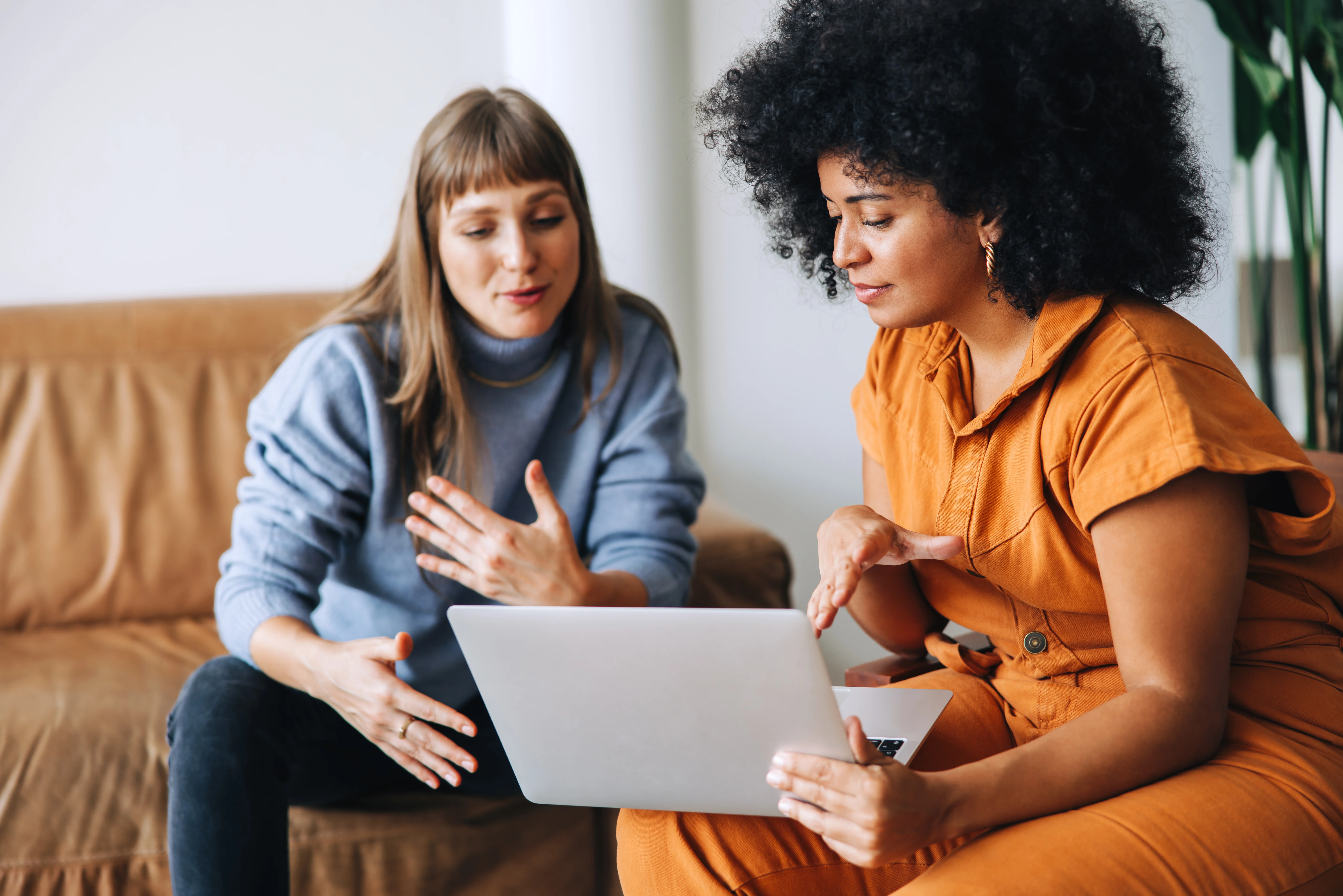 Two mental health professionals collaborating over a laptop, discussing complex cases and evidence-based treatment approaches